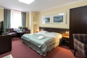 Una habitación de hotel con una cama con toallas. en Resort Plaza Spa, en Darłówko 17 fotos más