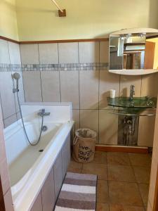 a bathroom with a tub and a sink and a mirror at Cosy duplex in Res les Barachois 3,Grand-Gaube in Grand Gaube