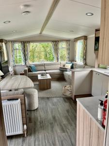 una sala de estar con un sofá y una mesa en Beautiful bideford bay holiday vans, en Bucks Mills