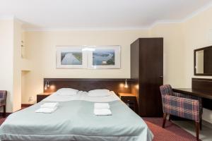 a hotel room with a bed and a desk at Resort Plaza Spa in Darlowko +15 photos
