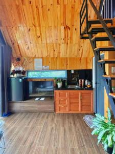 a kitchen with wooden ceilings and a staircase in a room at Homestay Mộc Hoa Viên in Bao Loc