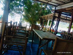 a group of chairs and a wooden table and chairs at Koh Phu Valley in Ko Jum