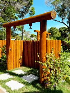 a wooden fence with a pergola in a yard at Pousada Sky Dream Beach Mutá Frente Mar By LVF in Porto Seguro