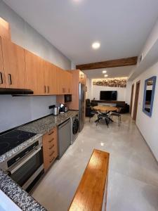 a kitchen with wooden cabinets and a table and a dining room at Apartamento La Fragua - A ESTRENAR - BRAND NEW in Chulilla +16 photos