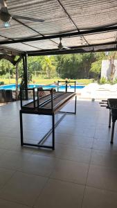 eine Bank unter einem Pavillon mit Pool in der Unterkunft Finca Anna Clara Vuelta la Barranca Santiago del Estero in Cardozos