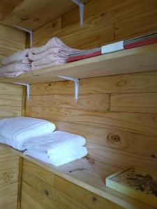 a wooden wall with shelves with towels and a book at La Cabana de Cocholgüe 45 in Tomé +30 photos