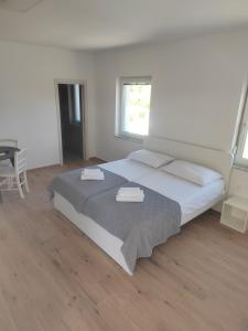 a bedroom with a large bed with two towels on it at Studio Apartma KIMI in Nova Gorica