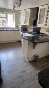 a kitchen with white cabinets and a black counter top at La single in Wednesbury