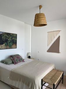 ein weißes Schlafzimmer mit einem Bett und einem Stuhl in der Unterkunft Hostidy Villa Horacia Resort in Sanlúcar de Barrameda + 32 Fotos