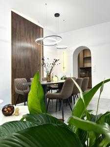 a dining room with a table and chairs and plants at Dubois Apartment - Self Check-In 20h in Wrocław