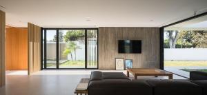 ein Wohnzimmer mit einem Sofa und einem Fernseher an der Wand in der Unterkunft Hostidy Villa Horacia Resort in Sanlúcar de Barrameda