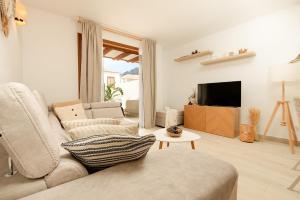 een woonkamer met een bank en een tv bij Home2Rest at Los Gigantes - 1 min to beach, restaurants, city center - 1bdr in Acantilado de los Gigantes
