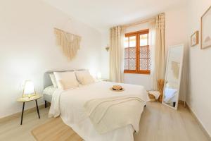 een witte slaapkamer met een bed en een spiegel bij Home2Rest at Los Gigantes - 1 min to beach, restaurants, city center - 1bdr in Acantilado de los Gigantes