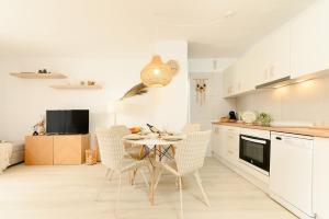 een keuken met een tafel en stoelen in een kamer bij Home2Rest at Los Gigantes - 1 min to beach, restaurants, city center - 1bdr in Acantilado de los Gigantes