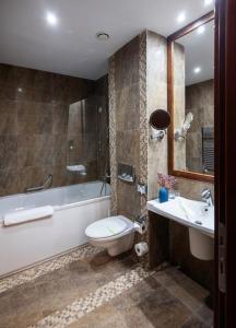 a bathroom with a tub and a toilet and a sink at Poiana Brasov Alpin Resort Apartment in Poiana Brasov