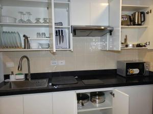 a kitchen with white cabinets and a black counter top at 803 - Quiet Condo in City Centre in Davao City
