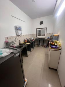 a kitchen with a sink and a refrigerator at Cozy Retreat In the heart of Jabalpur in Jabalpur