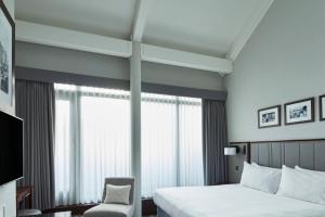 a hotel room with a bed and a chair at Manchester Marriott Victoria & Albert Hotel in Manchester