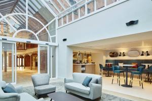 an open living room with chairs and a table at Manchester Marriott Victoria & Albert Hotel in Manchester