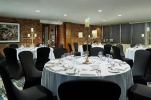 a conference room with white tables and black chairs at Manchester Marriott Victoria & Albert Hotel in Manchester