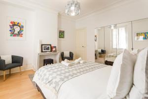 サン・マンデにあるAppartement cosy et confortable Paris St Mandéの白いベッドルーム(ベッド1台、暖炉付)