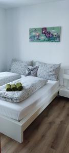 ein weißes Bett mit zwei grünen Kissen darauf in der Unterkunft Appartement Gern in Alpendorf + 25 Fotos