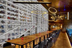 a dining room with a long table and a wall of plates at W London in London
