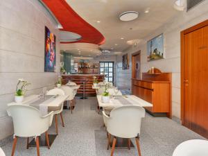 a restaurant with white tables and white chairs at B&B HOTELS Hotel Prestige Ornago in Ornago