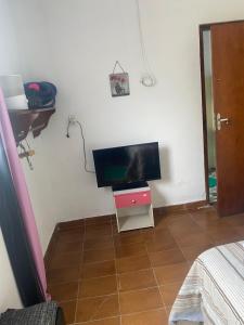 a tv sitting on a stand in a room at Casa roxa in Itatiaia