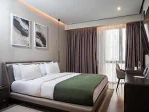 a hotel room with a large bed and a desk at La Brisa Boutique Hotel in Dhërmi