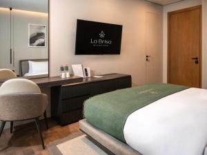 a bedroom with a desk and a bed and a mirror at La Brisa Boutique Hotel in Dhërmi