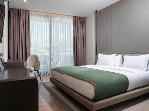 a hotel room with a bed and a desk and window at La Brisa Boutique Hotel in Dhërmi