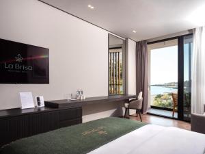 a hotel room with a bed and a desk and a window at La Brisa Boutique Hotel in Dhërmi