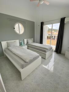 マサロンにあるCasa Sophie mit großem Poolの白いベッドルーム(ベッド2台、鏡付) +14枚の写真