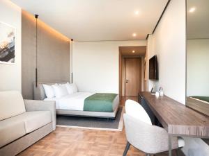 a hotel room with a bed and a desk at La Brisa Boutique Hotel in Dhërmi