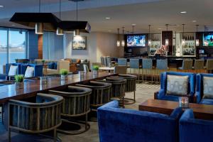 a restaurant with a long table and chairs and a bar at Kansas City Airport Marriott in Kansas City