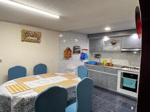 una cucina con tavolo e sedie blu in una stanza di Hospedaje Los Cedros- Monguí a Monguí
