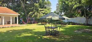 a table and chairs under an umbrella in a yard at The lit garden place in Kisumu