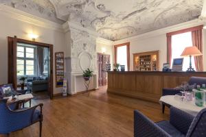 a large room with a reception desk and a room with avertisement at Hotel Schloss Neustadt-Glewe in Neustadt-Glewe