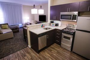 Una cocina y una sala de estar en una habitación de hotel. en TownePlace Suites by Marriott Boynton Beach, en Boynton Beach