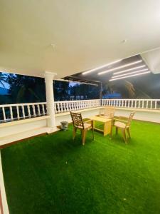 a room with a table and chairs on a balcony at Berghof villa Rooms in Cochin