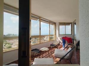 a living room with chairs and a couch and windows at Apartamento CABO HUERTAS in Alicante