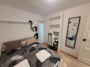 Schlafzimmer mit einem Bett und einem Spiegel in der Unterkunft Habitaciones con vistas Madrid in Madrid