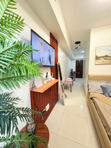 ein Wohnzimmer mit einem Fernseher an der Wand in der Unterkunft DandD's Place Studio Unit 1 with Free Netflix in Davao City