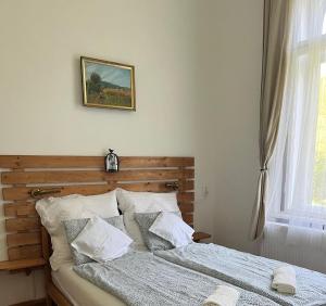 a bed in a bedroom with a picture on the wall at Eitner Villa Apartman in Kőszeg