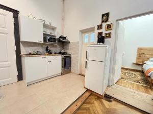 a kitchen with white cabinets and a white refrigerator at Eitner Villa Apartman in Kőszeg