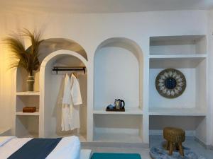 a bedroom with white shelves and a bed and a mirror at Alaya at volcano in Baturaja +12 photos