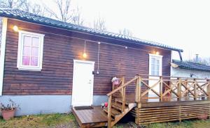 a wooden house with a porch and a white door at Duplex in Alingsås