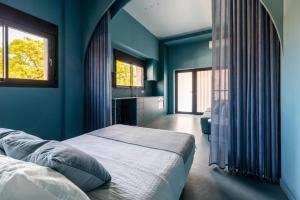 1 dormitorio azul con 1 cama y 2 ventanas en POINT BEACH Blue, en Valencia