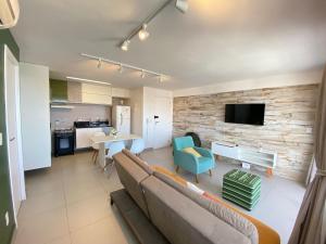 a living room with a couch and a dining room at Helbor My Way - Compactos de luxo in Fortaleza